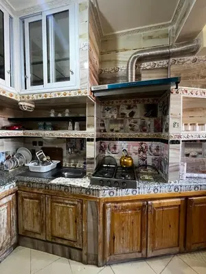 a kitchen with wooden cabinets and a stove at Apartment in Bassatine targa in Marrakech