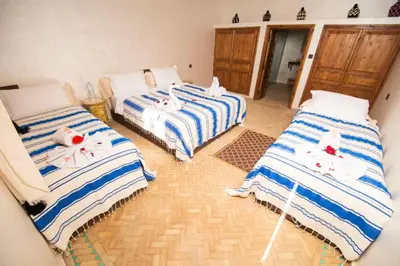 a room with three beds with towels on them at Villa Dar Saada in Marrakech