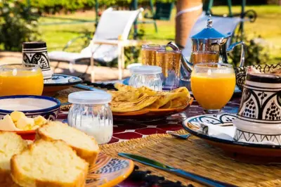 a table with plates of bread and glasses of orange juice at Villa Dar Saada in Marrakech