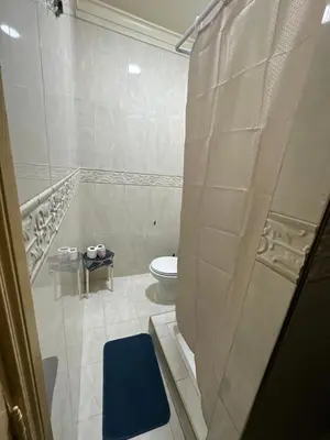 a bathroom with a toilet and a blue rug at مراكش كليز in Marrakech