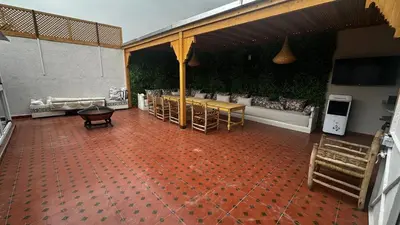 a room with a patio with a table and a couch at Riad Dari and spa in Marrakech