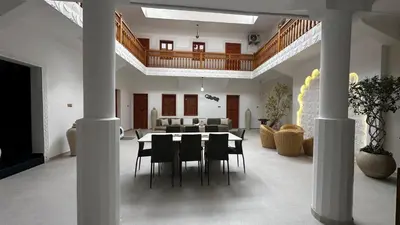 a dining room and living room with a table and chairs at Riad Dari and spa in Marrakech
