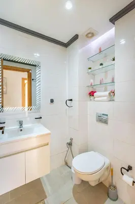 a white bathroom with a toilet and a sink at Appartement familial 2 ch Wi-Fi 15 min centre in Marrakech