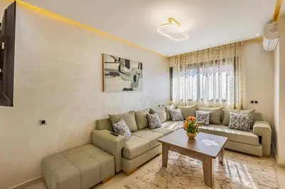 a living room with a couch and a table at Appartement familial 2 ch Wi-Fi 15 min centre in Marrakech