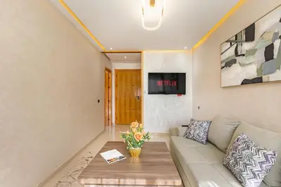 a living room with a couch and a table at Appartement familial 2 ch Wi-Fi 15 min centre in Marrakech