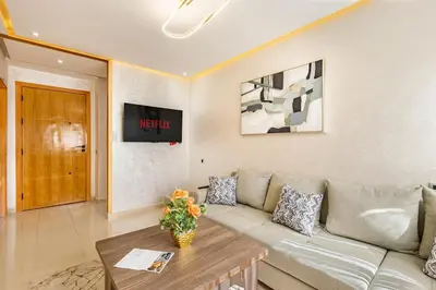 a living room with a couch and a table at Appartement familial 2 ch Wi-Fi 15 min centre in Marrakech