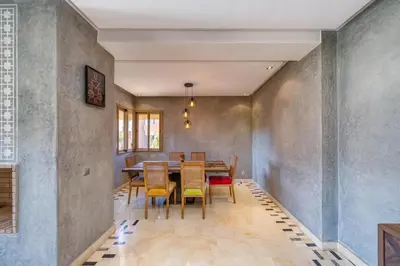 a dining room with a table and chairs at Family Apartment 3 Bedrooms Prestigia with Pool in Marrakech