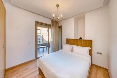 a bedroom with a large white bed and a window at Family Apartment 3 Bedrooms Prestigia with Pool in Marrakech