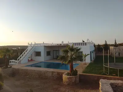 a house with a swimming pool in front of it at Alexandra Nomade - Maison de transition & séjours de répit in Marrakech