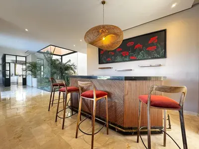 a kitchen with a bar with stools at 4-Suite Villa, Private Pool at Jade Garden in El Rhechat