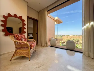 a living room with a wicker chair and a mirror at 4-Suite Villa, Private Pool at Jade Garden in El Rhechat