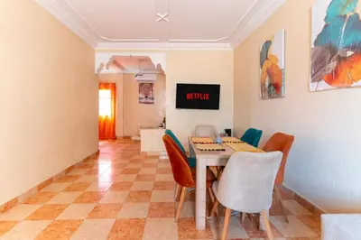 a dining room with a table and chairs at bel appartement très calme in Marrakech