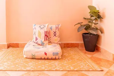 a bean bag chair with pillows and a potted plant at bel appartement très calme in Marrakech