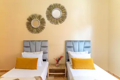 two beds in a room with mirrors on the wall at bel appartement très calme in Marrakech