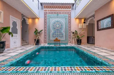 a swimming pool in a house with a tiled floor and a tile wall at Riad Dar Al Ghali in Marrakech