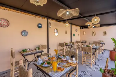 a dining room with tables and chairs and chandeliers at Riad Dar Al Ghali in Marrakech