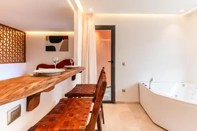 a kitchen with a table and a bath tub at Cocon Balnéo de Gueliz - Central & Balcon in Marrakech