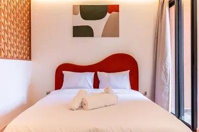 a bedroom with a bed with a stuffed animal on it at Cocon Balnéo de Gueliz - Central & Balcon in Marrakech