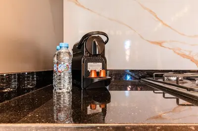 a bottle of water on a counter next to a stove at Cocon Balnéo de Gueliz - Central & Balcon in Marrakech