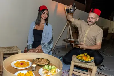 a man and a woman holding up a picture of food at Riad Nowara And Spa in Marrakech