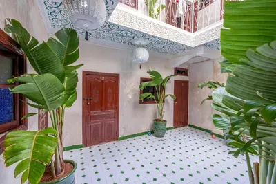 a room with potted plants and a wooden door at Riad Nowara And Spa in Marrakech