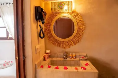 a bathroom with a mirror and a sink with red roses at Riad Nowara And Spa in Marrakech