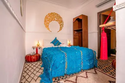 a bedroom with a bed with a blue comforter at Riad Nowara And Spa in Marrakech