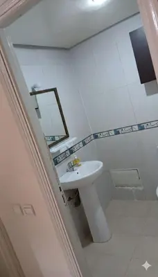 a white bathroom with a sink and a mirror at Au Coeur de L'hivernage P21 in Marrakech