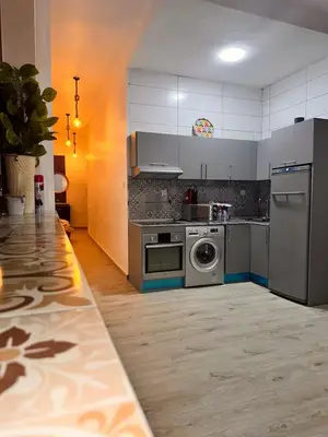 a kitchen with a stove and a washing machine at Studio Mhamid 10 in Marrakech