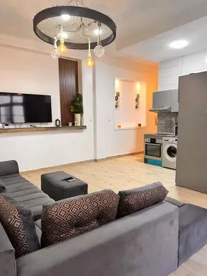 a living room with a couch and a kitchen at Studio Mhamid 10 in Marrakech