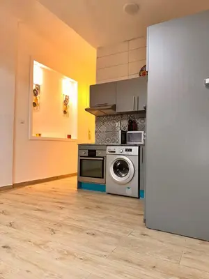 a kitchen with a stove and a washing machine at Studio Mhamid 10 in Marrakech