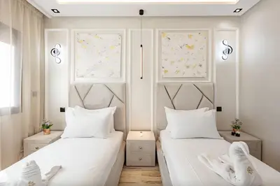 two beds in a bedroom with white walls and windows at Apartment in the heart of Marrakech - 2BR in Marrakech
