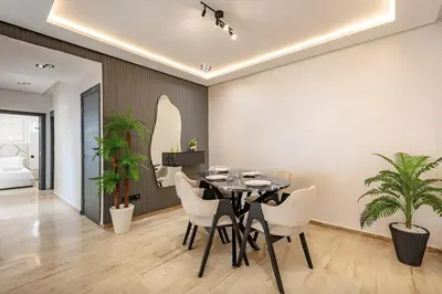 a dining room with a black table and white chairs at Apartment in the heart of Marrakech - 2BR in Marrakech