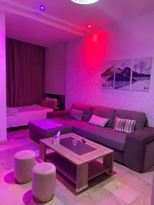 a living room with a couch and pink lighting at Studio moderne et calme à Guéliz in Marrakech