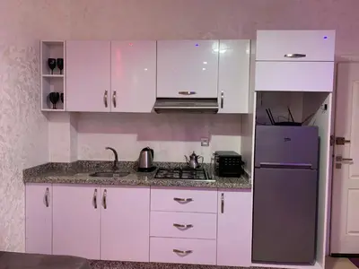 a kitchen with white cabinets and a purple refrigerator at Studio moderne et calme à Guéliz in Marrakech