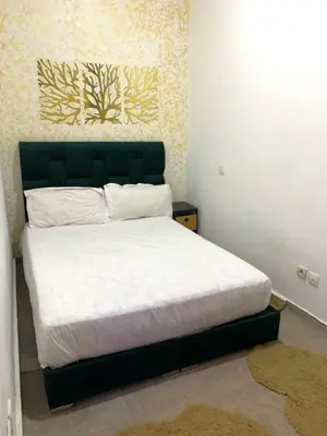 a bedroom with a bed with a green headboard at Studio moderne et calme à Guéliz in Marrakech