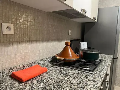 a kitchen counter with a stove with a pot on it at Apartment with swimming pool full air-conditioned in Marrakech