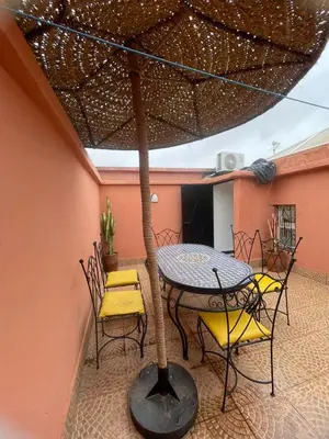 a patio with a table and chairs on a patio at Riad Zou Palm in Marrakech
