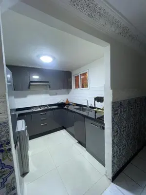 a large kitchen with black cabinets and a sink at Riad Zou Palm in Marrakech