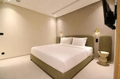 a bedroom with a large white bed and a television at Le Petit Medina - 4prs - Wifi - Semlalia in Marrakech