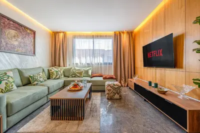 a living room with a couch and a tv at Le Grand Jazzy in Marrakech