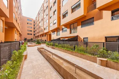 a walkway in front of a building with plants at Le Grand Jazzy in Marrakech
