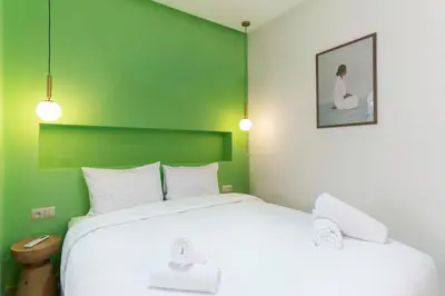 a bedroom with a large white bed with a green wall at Le Parisien Modern Studio in Hivernage in Marrakech