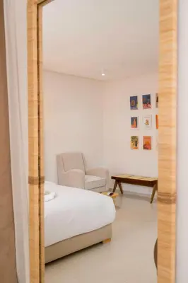 a bedroom with a bed and a chair and a mirror at Studio Horizon Marrakech Station in Marrakech