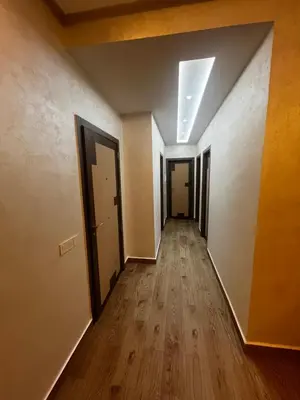 an empty hallway with two doors and wood floors at L'Oasis Des Amis in Marrakech