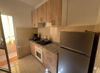 a kitchen with a stainless steel refrigerator and wooden cabinets at RS 13 by KMREI Properties in Marrakech