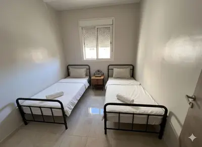 two beds in a small room with a window at RS 13 by KMREI Properties in Marrakech