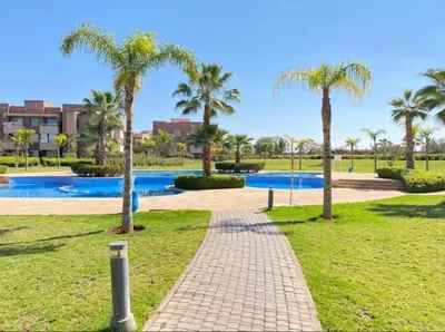 a brick walkway in a park with palm trees at Fabuleux T4 110 m2 prestigia Luxury in Marrakech