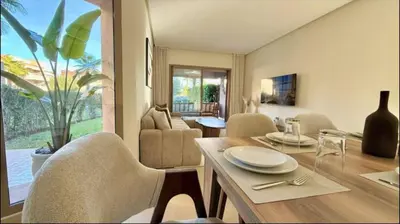 a dining room with a table and chairs and a living room at Fabuleux T4 110 m2 prestigia Luxury in Marrakech
