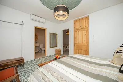a bedroom with a bed and a flat screen tv at Riad Timitar in Marrakech